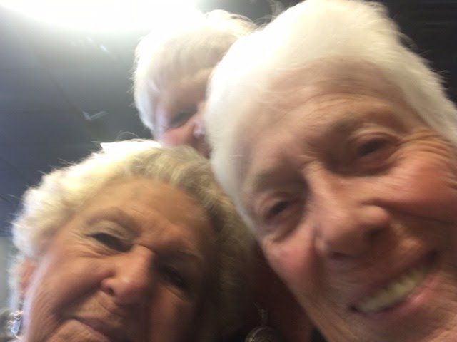 Three older women are posing for a picture and smiling