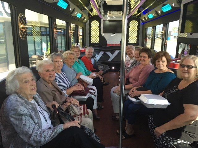 A group of older women are sitting on a bus