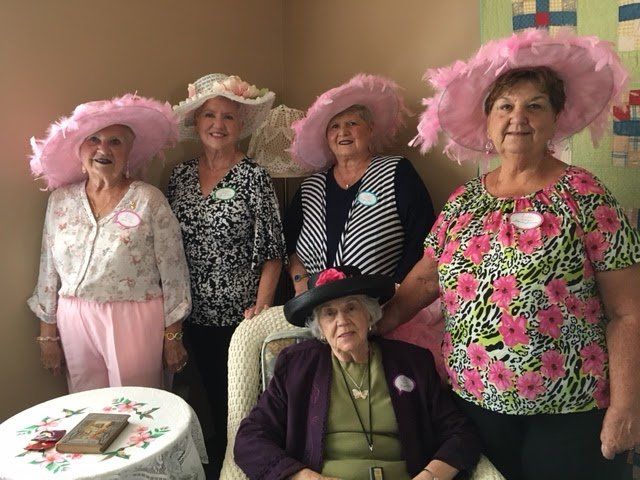 A group of women wearing pink hats are posing for a picture