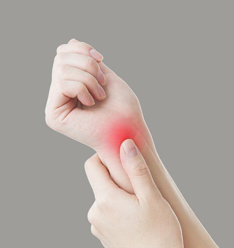 a woman is holding her wrist in pain from Carpal Tunnel Syndrome