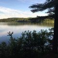 A lake with trees in the foreground and mountains in the background.