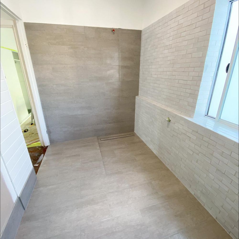 Empty Bathroom With Light Grey Tile Floor and Walls — AGM Flooring & Tiling in Hidden Valley, QLD