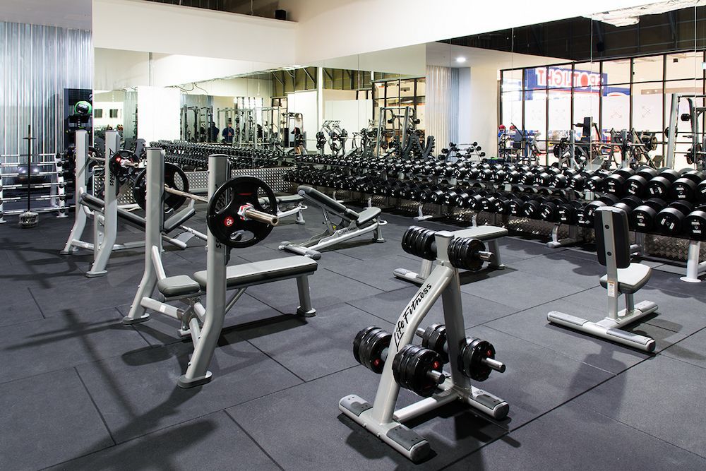 A Well-equipped Gym With  Grey Flooring and Mirrors Reflect the Equipment — AGM Flooring & Tiling in Hidden Valley, QLD