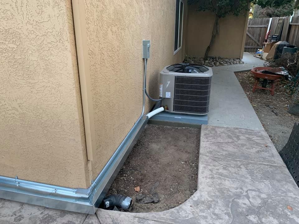 Bryant AC unit with metal line set chase installed along home exterior by RPM HVAC Service Inc.