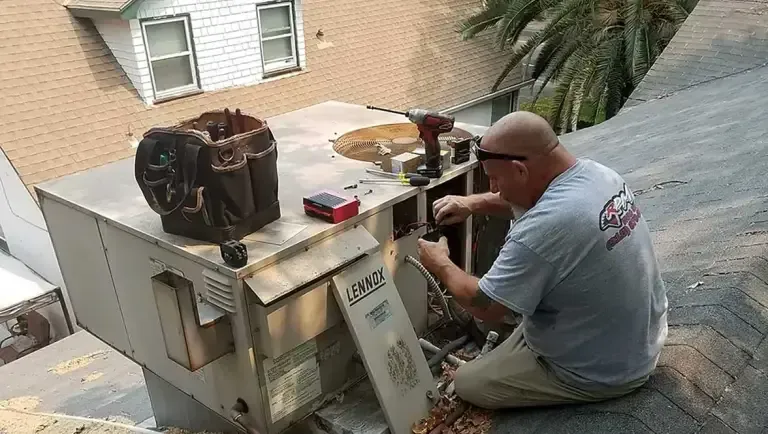 Technician performing maintenance on a Lennox rooftop HVAC unit using hand tools.