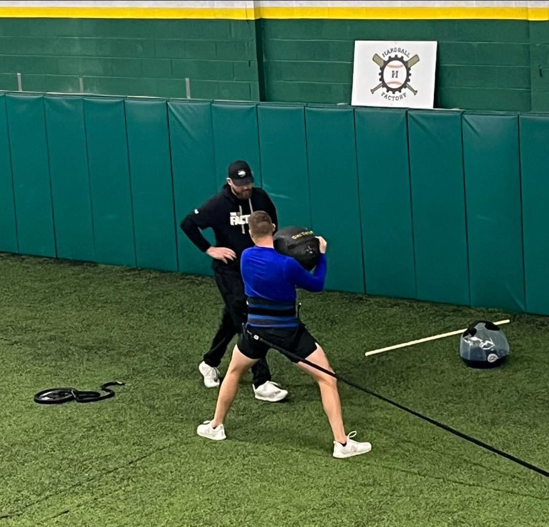 A man in a blue shirt is holding a ball while another man stands behind him — Elkton, MD — Maryland Legends Baseball