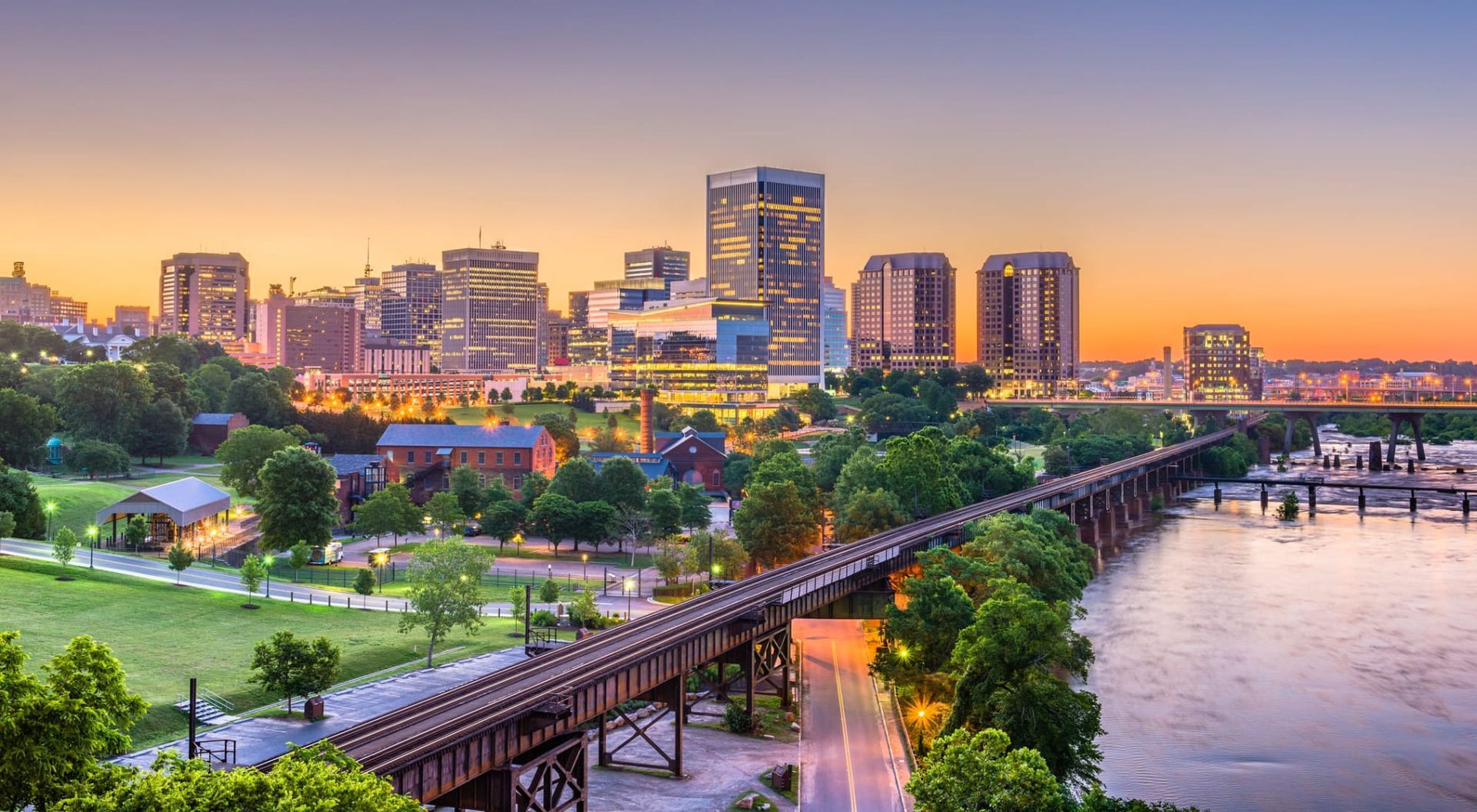 An aerial view of a city skyline with a bridge over a river in the foreground.