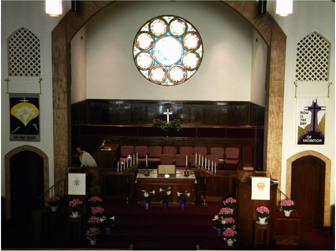 A church with a stained glass window and a cross on the wall