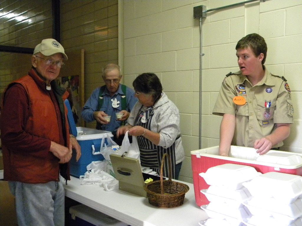 A group of people are standing around a table in a room.