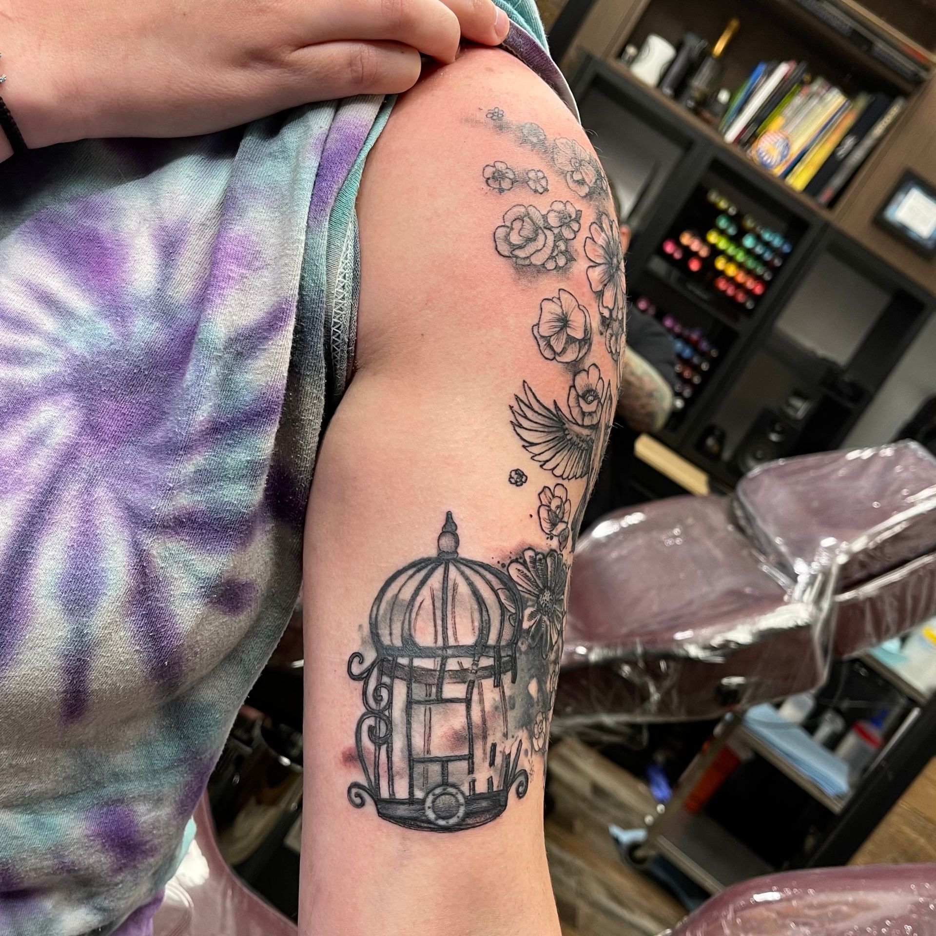 Birdcage with bird and flowers tattoo