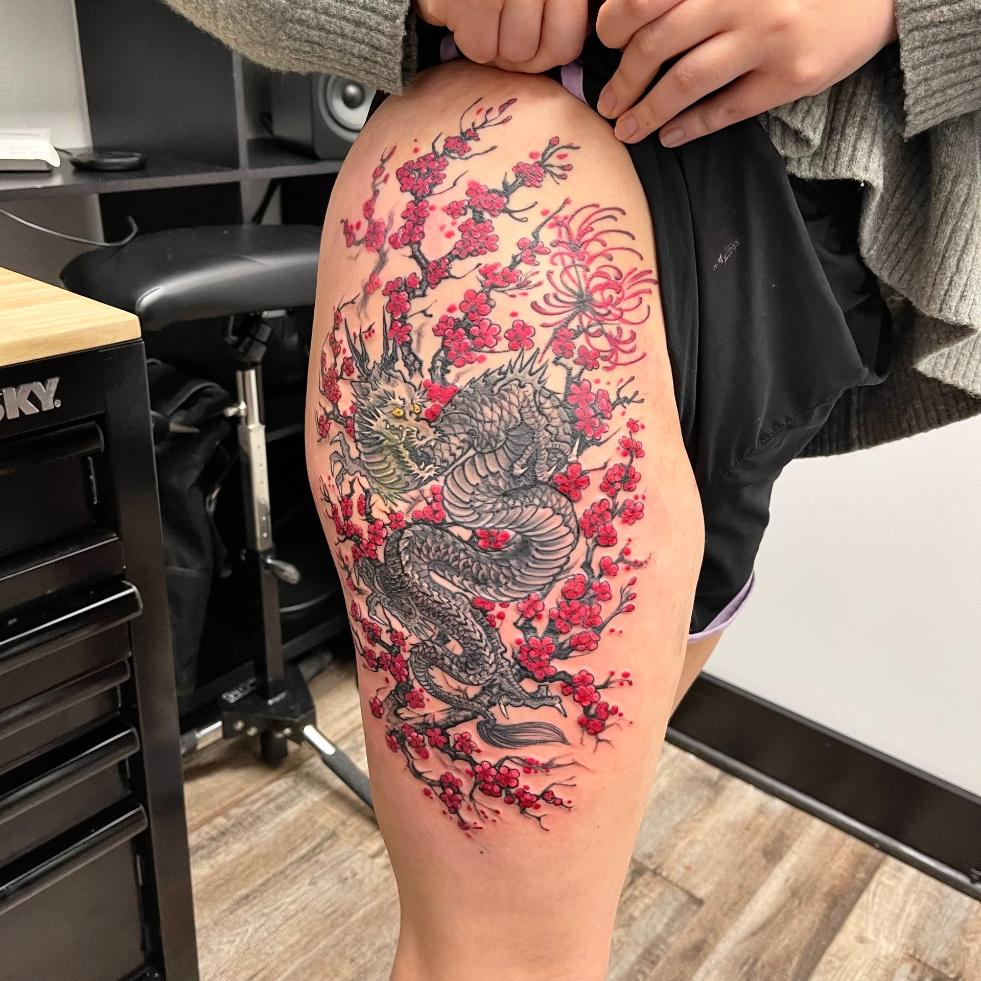 Large dragon in red flowers tattoo 