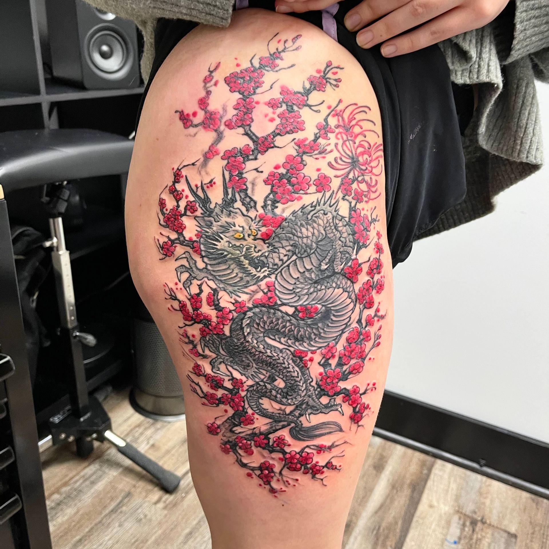 Dragon in red flowers tattoo
