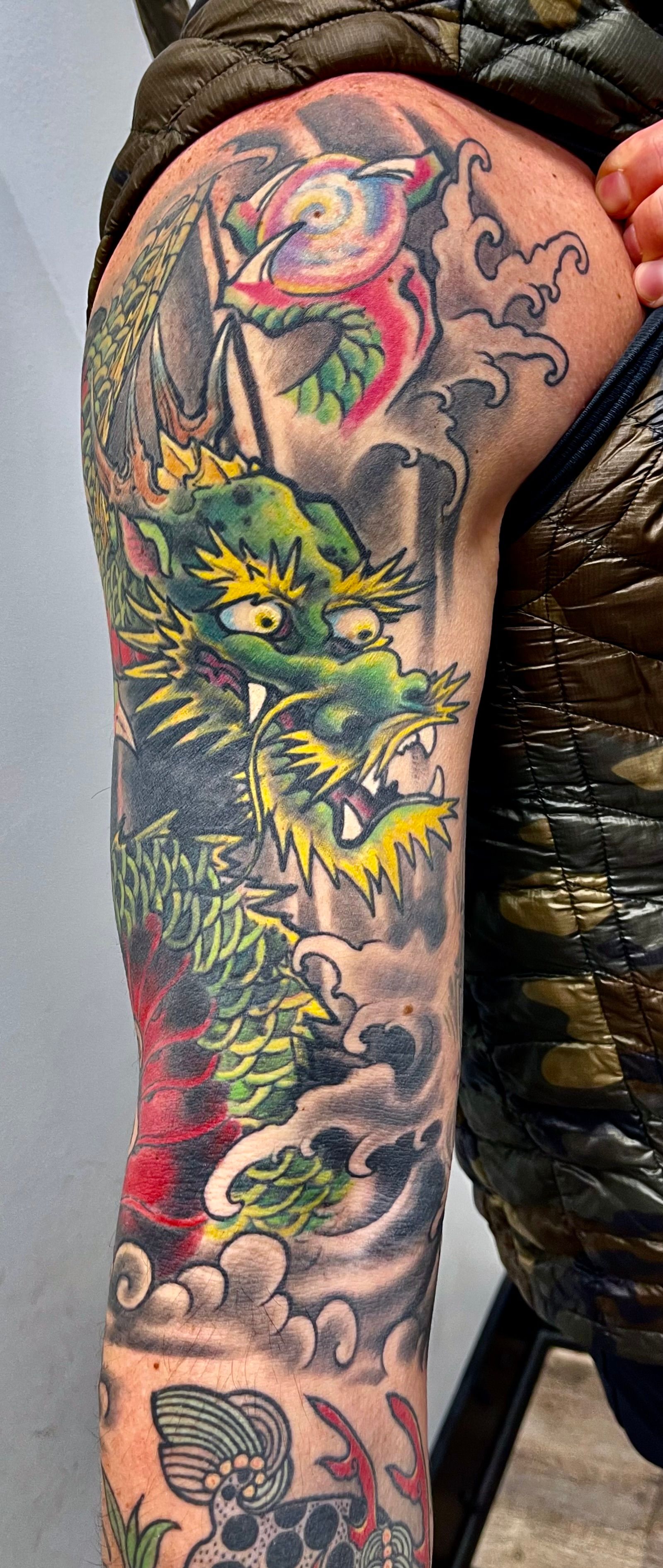 Colorful green and orange dragon tattoo
