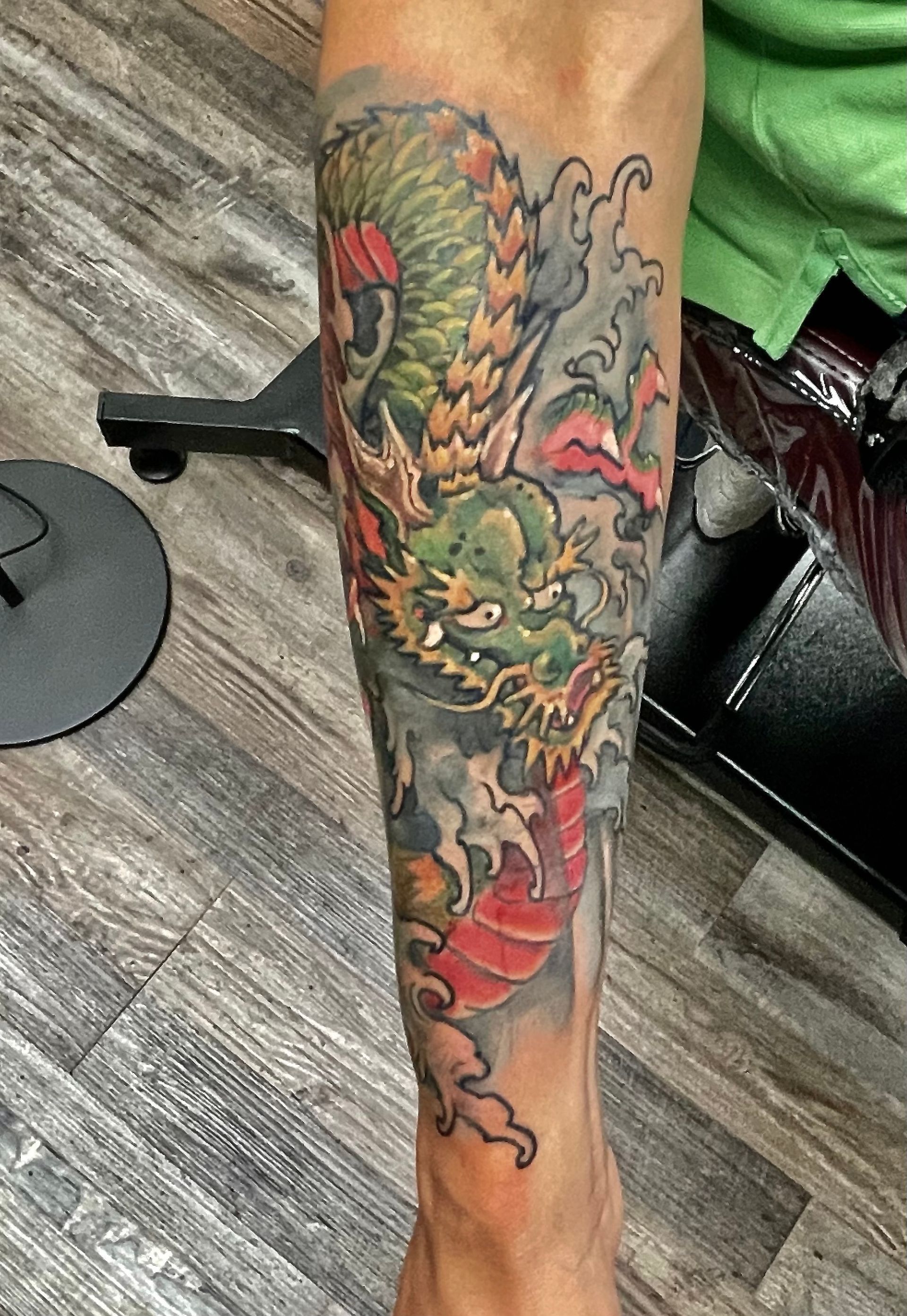 Olive and gray dragon in water tattoo