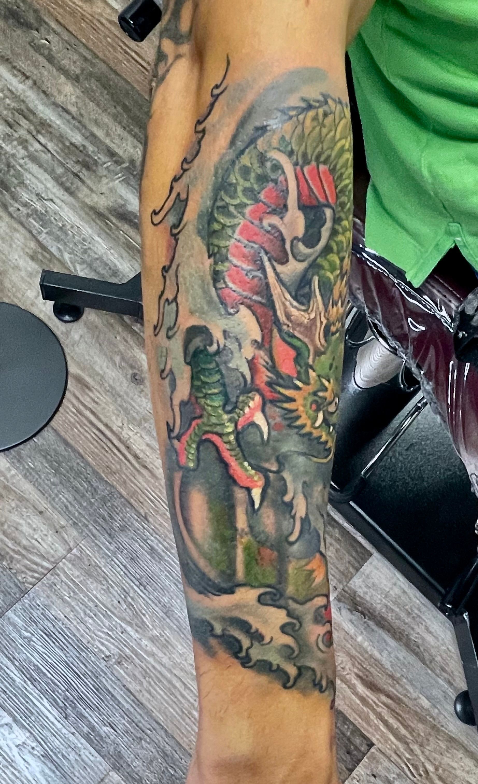 Olive and gray dragon in water tattoo