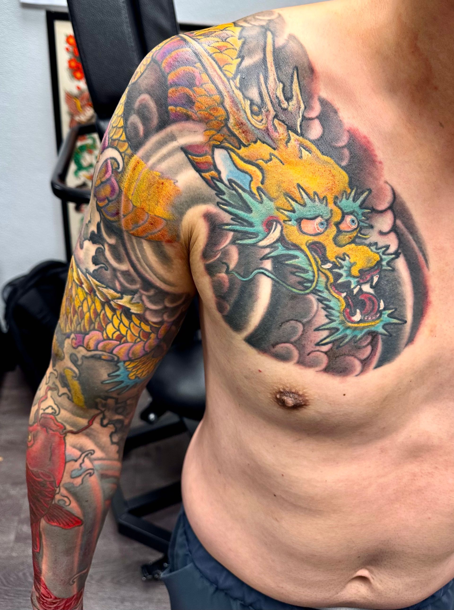 Golden dragon in waves tattoo on shoulder and arm