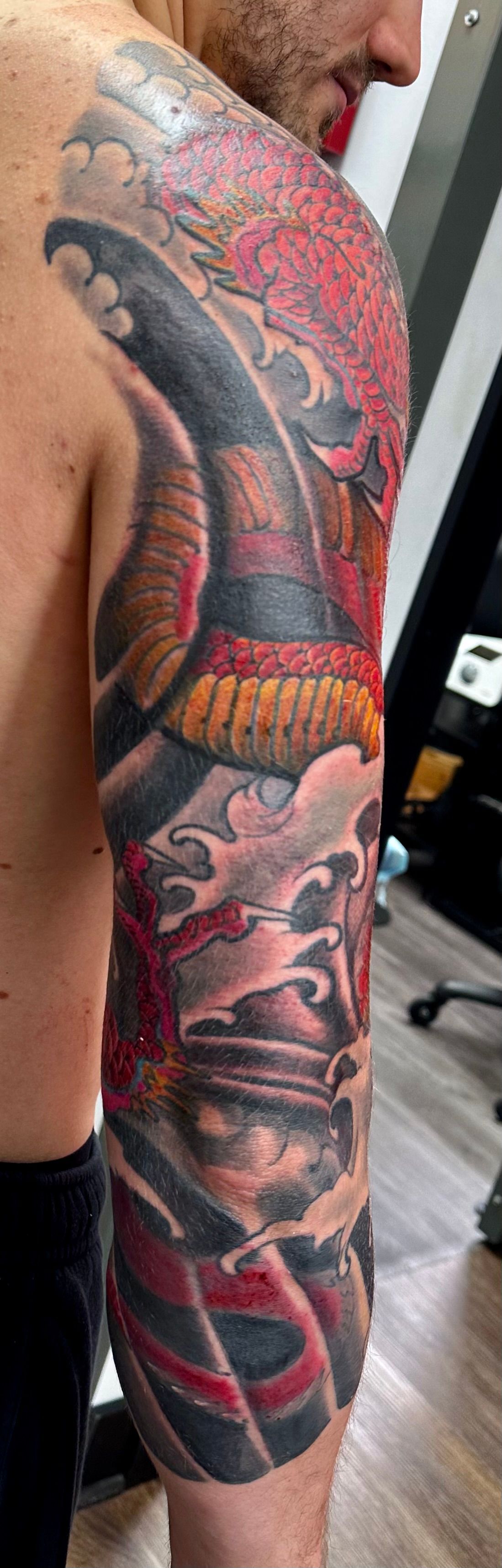 Red dragon in waves tattoo