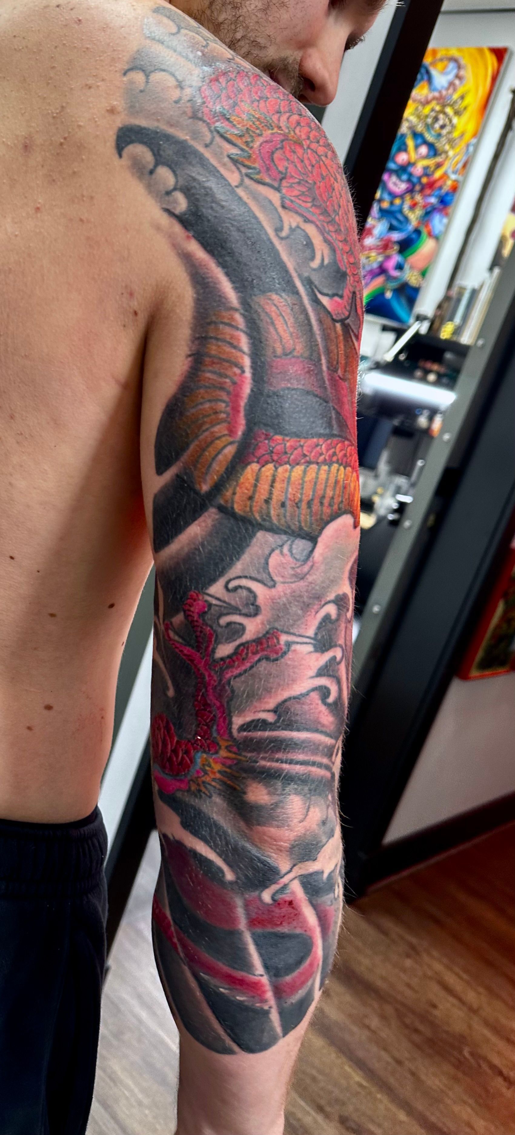 Red dragon and waves sleeve tattoo