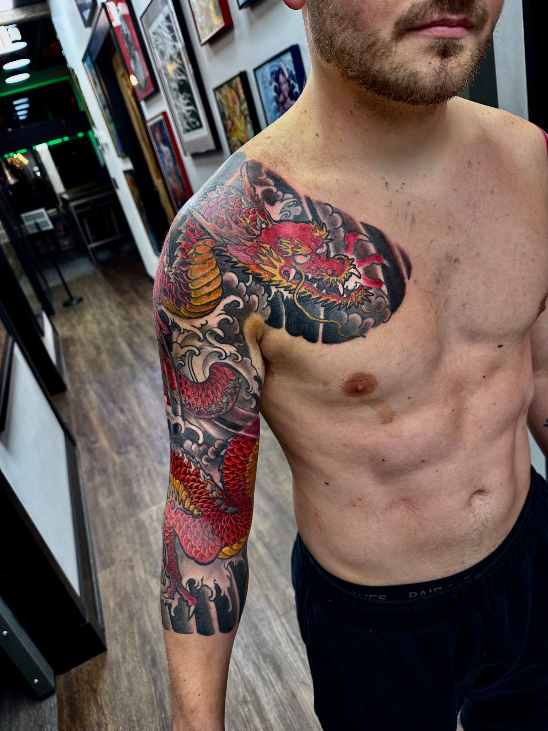 Red dragon in waves sleeve tattoo