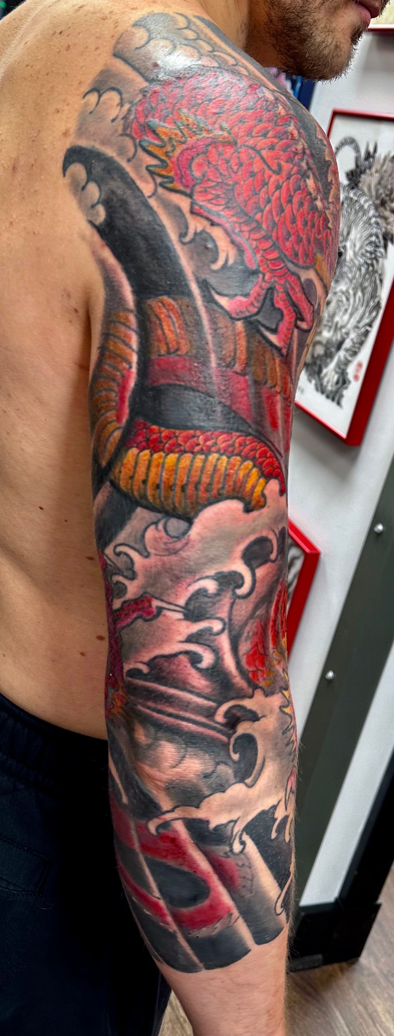 Red dragon with waves sleeve tattoo