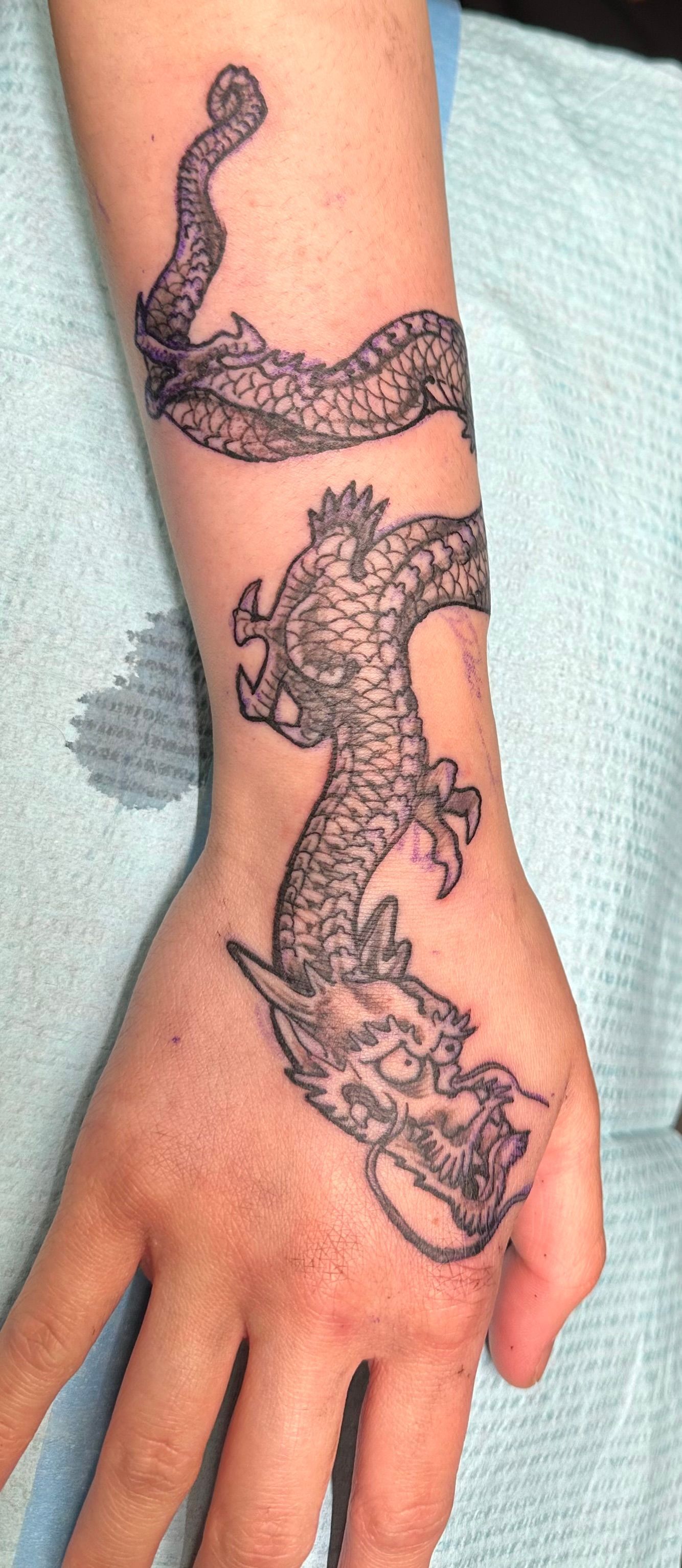 Dragon outline tattoo on wrist