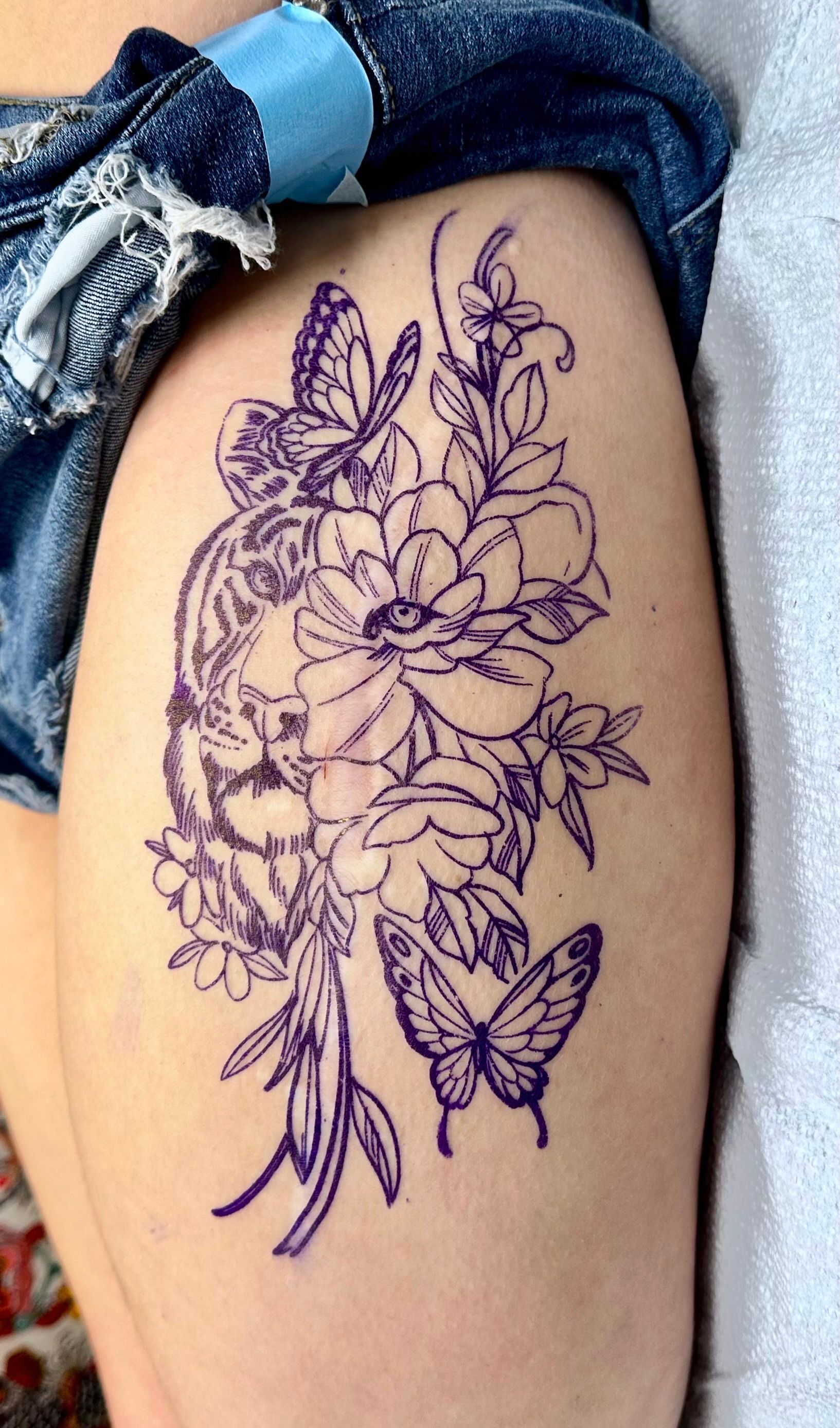 Lion and butterfly tattoo used as cover for scar