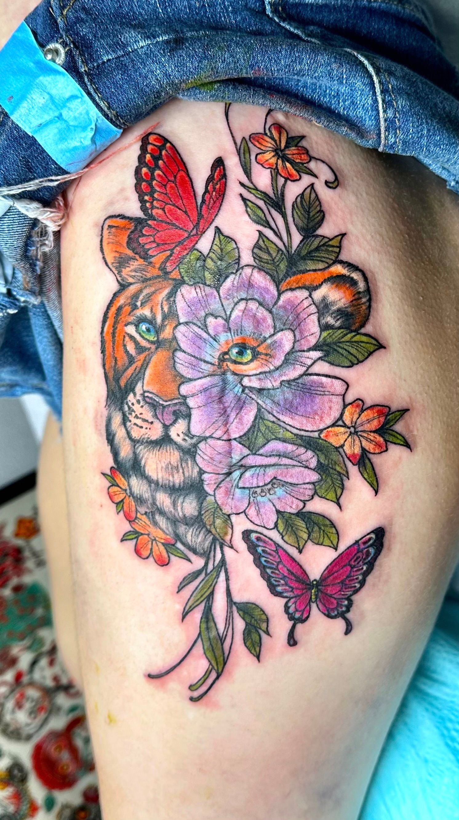 Lion and butterfly tattoo used to cover a scar