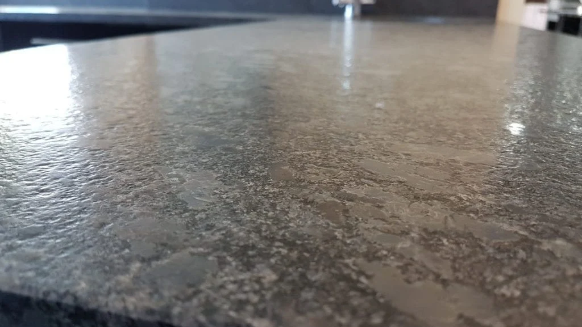 Close-up of a dark grey, textured countertop with a slight shine.