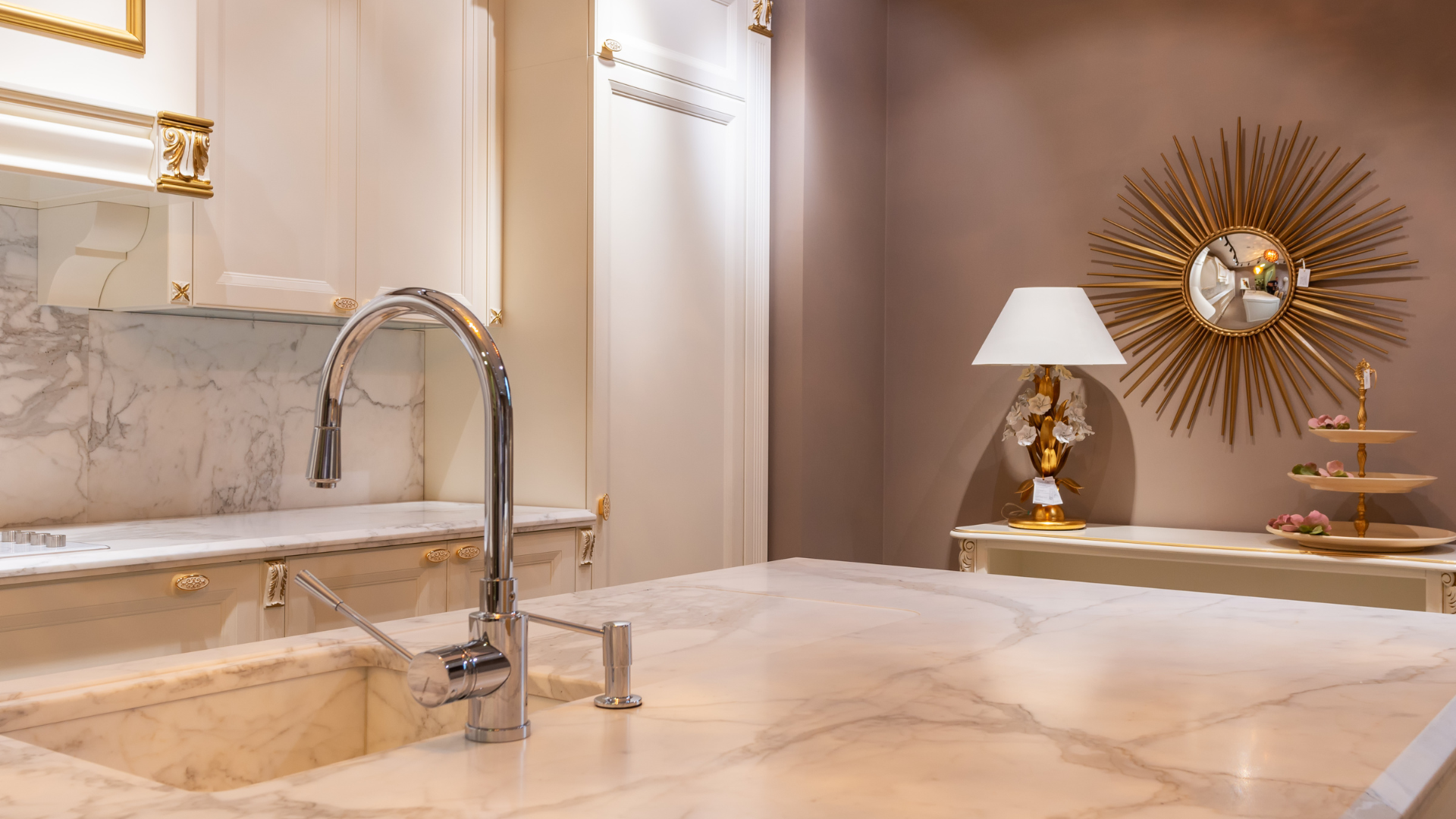Luxurious kitchen with a marble countertop, faucet, and gold accents.