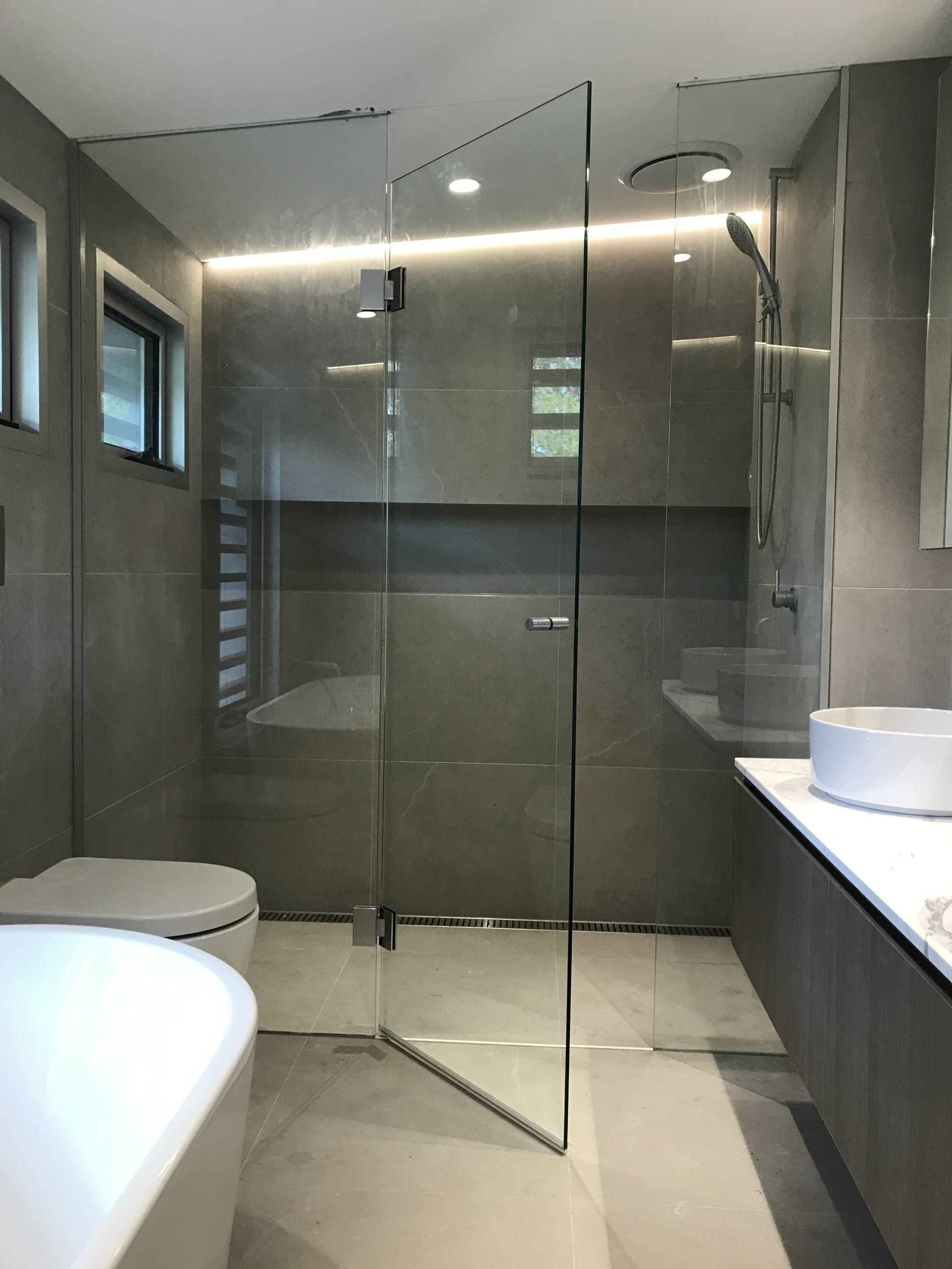 A bathroom with a toilet a sink and a walk in shower