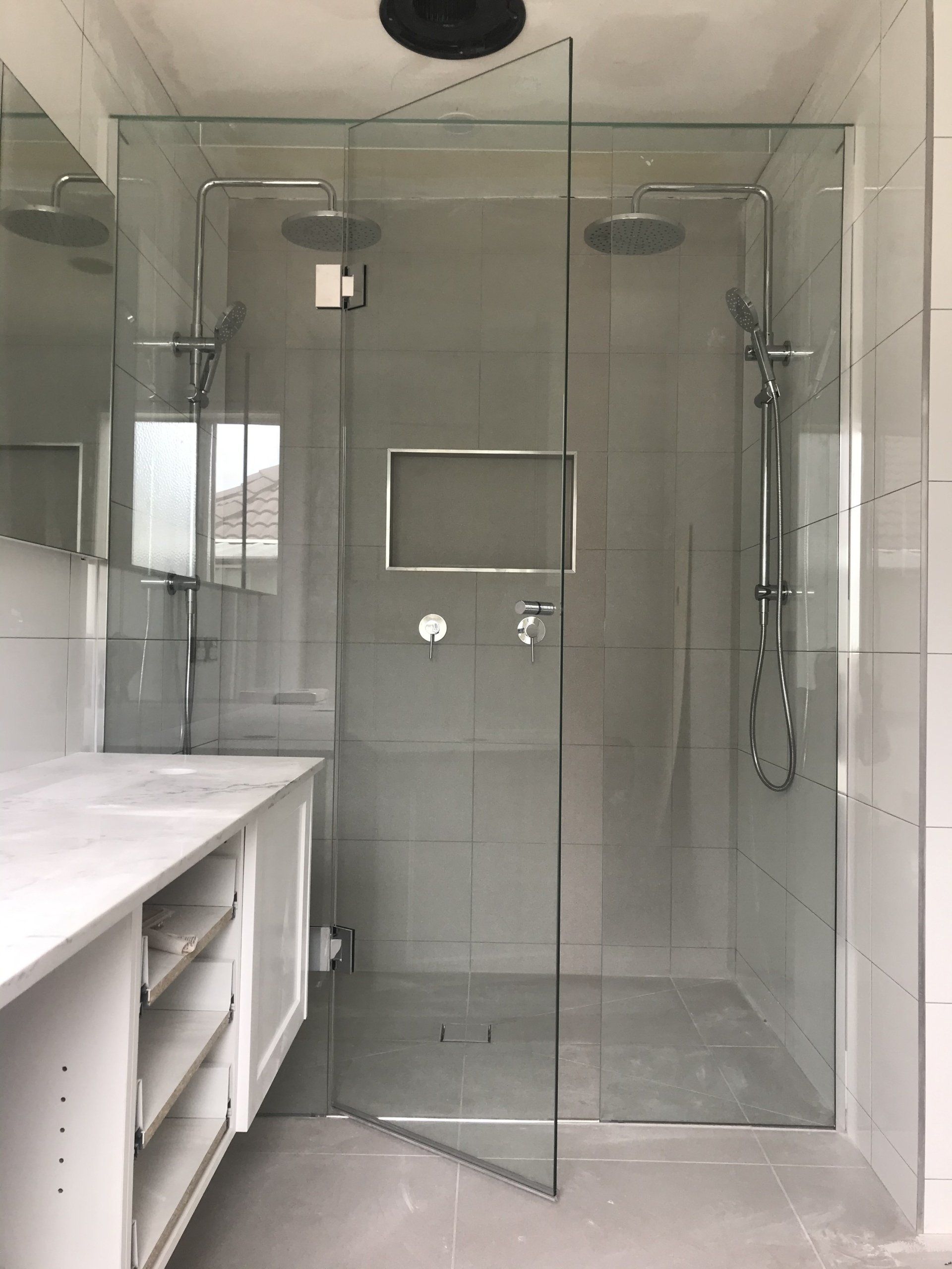 A bathroom with a walk in shower and a sink.