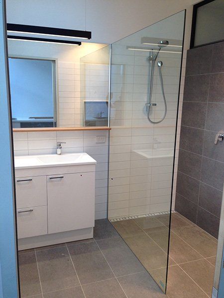 A bathroom with a sink and a walk in shower