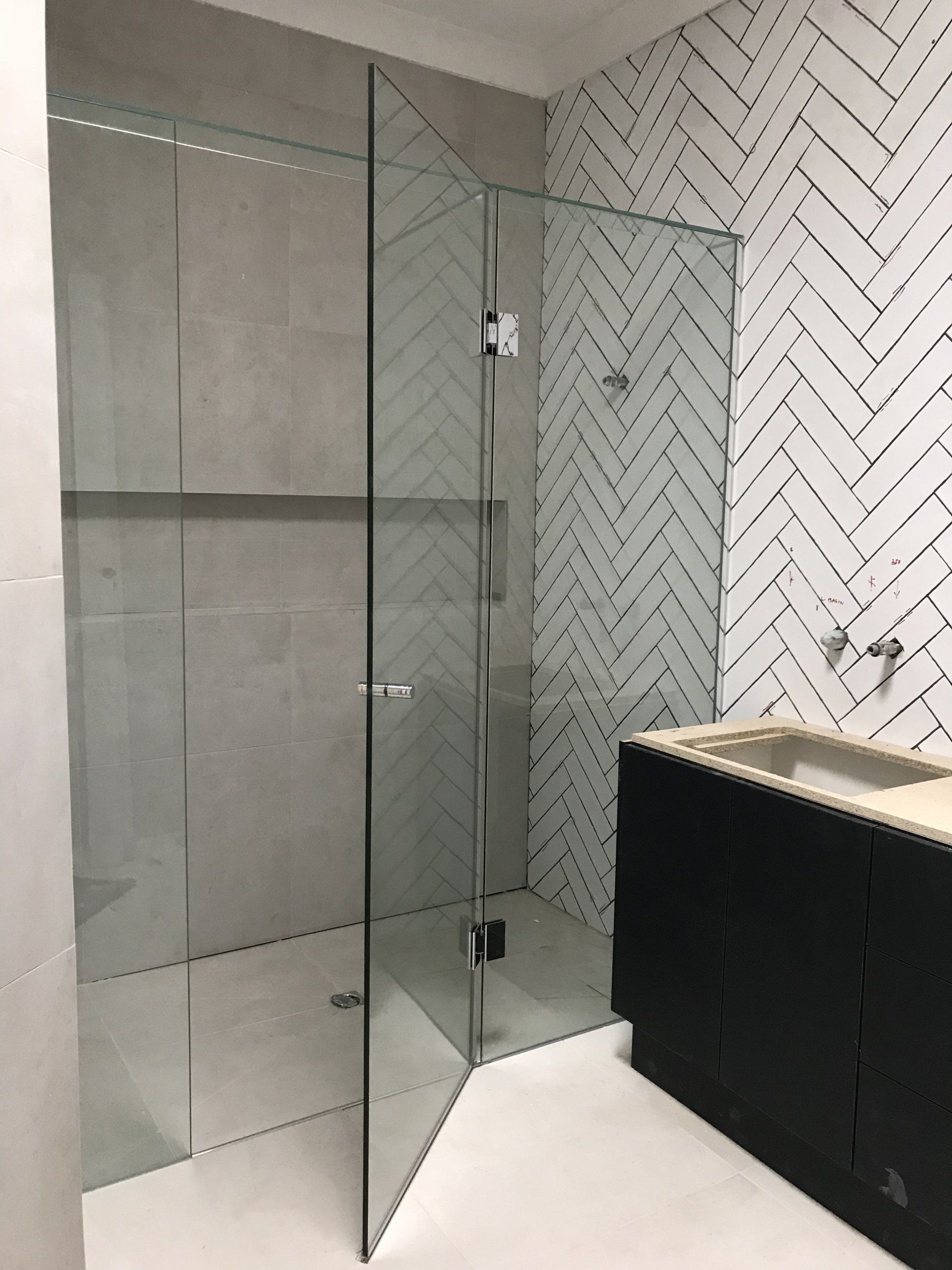 A bathroom with a walk in shower and a sink.