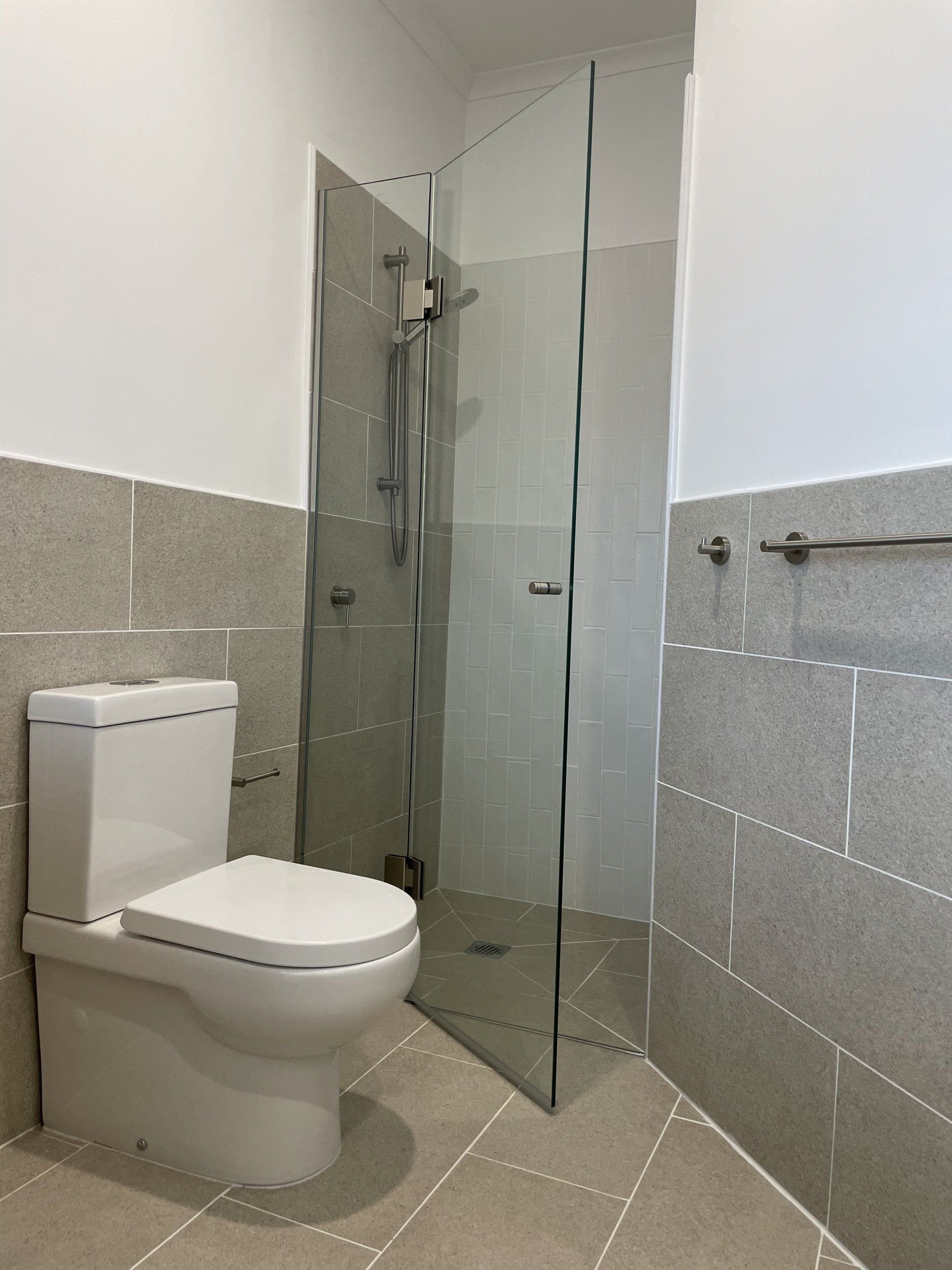 A bathroom with a toilet and a walk in shower.