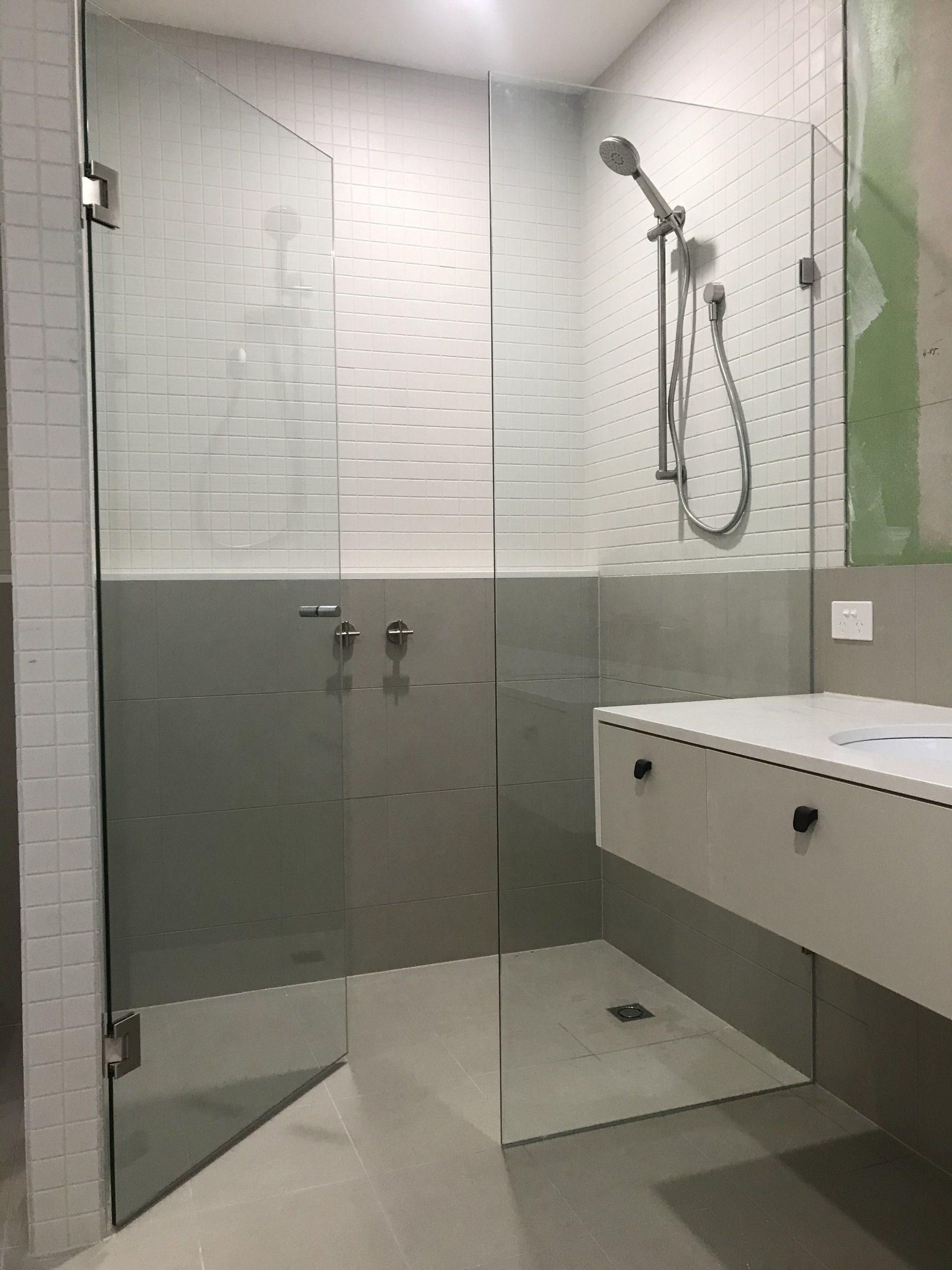 A bathroom with a walk in shower and a sink.