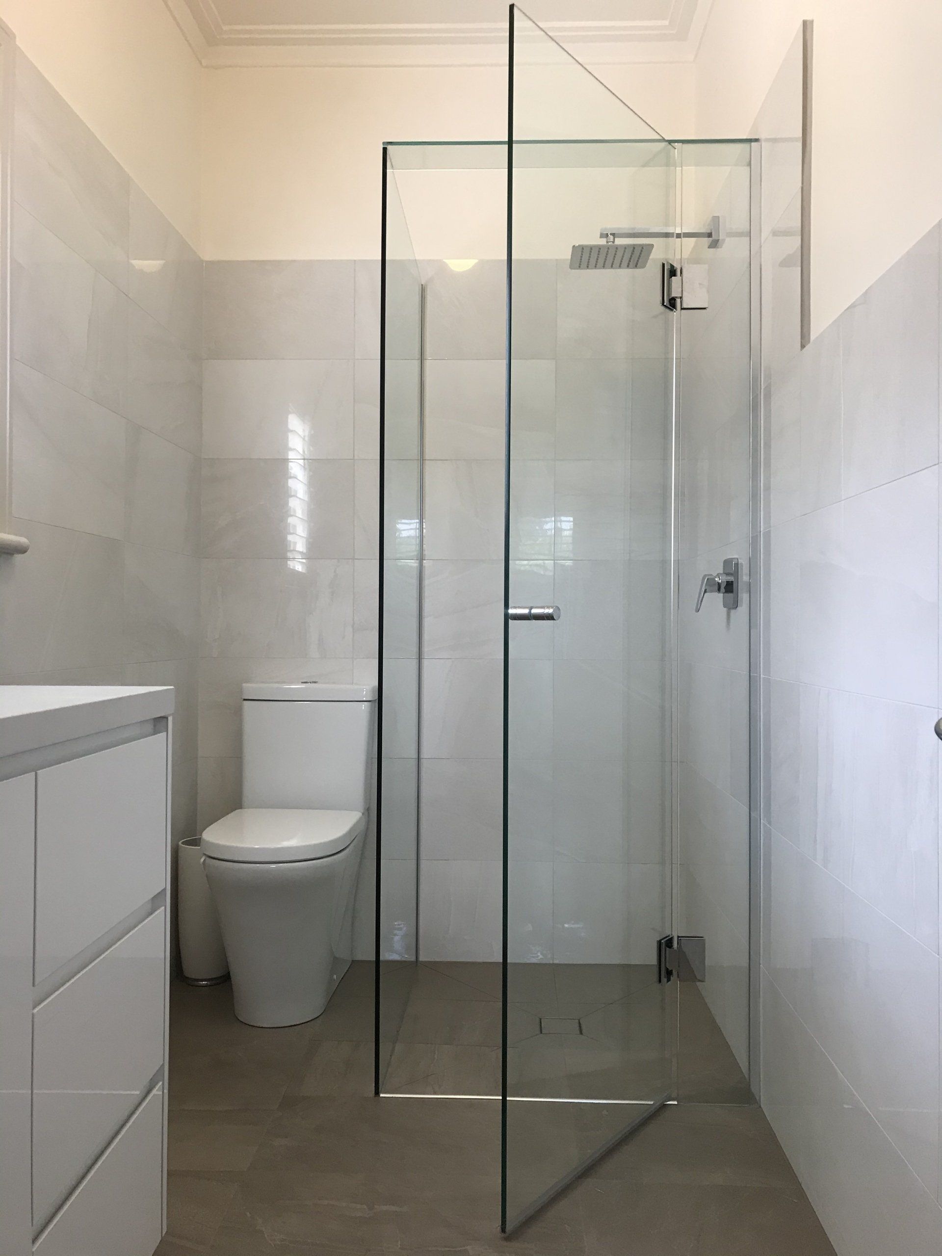 A bathroom with a toilet , sink and walk in shower.