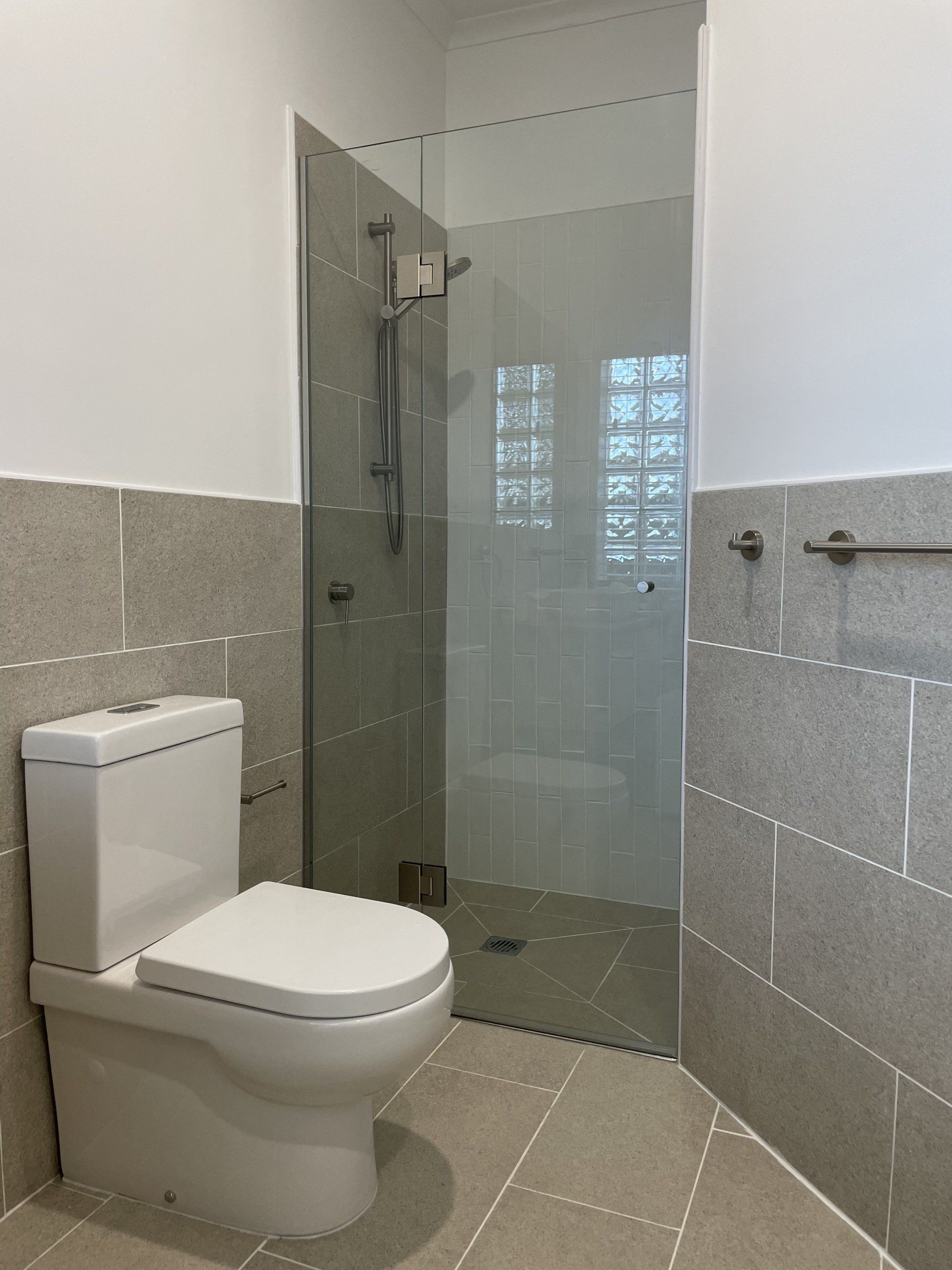 A bathroom with a toilet and a walk in shower.