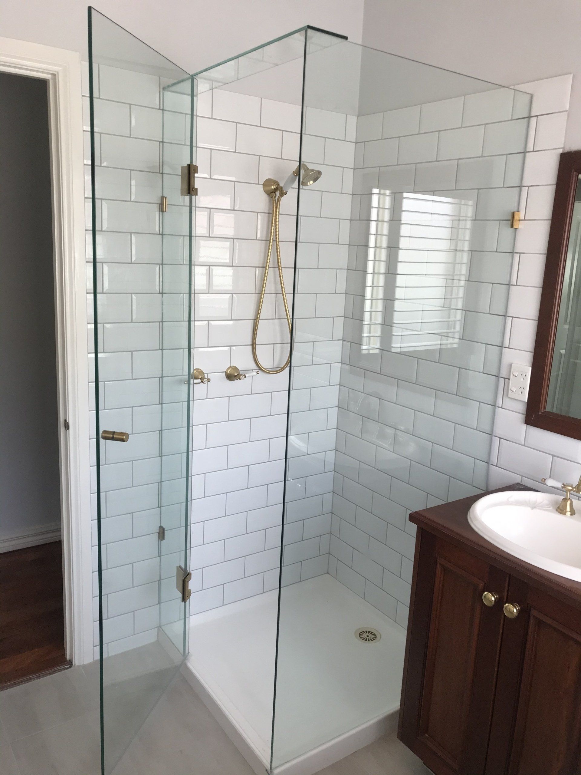 A bathroom with a walk in shower and a sink.