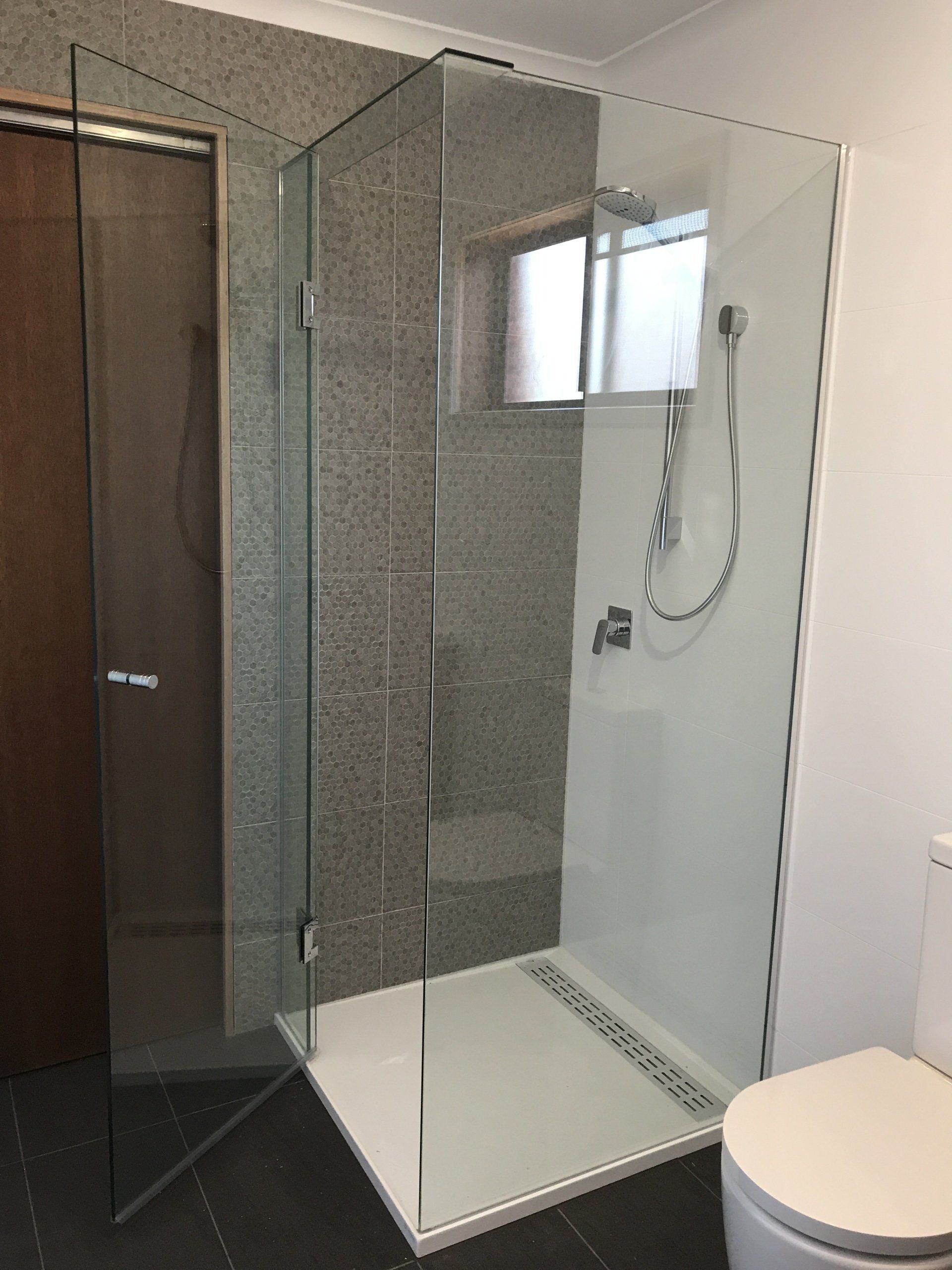 A bathroom with a walk in shower and a toilet.