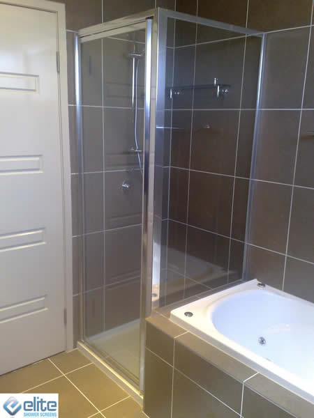 A bathroom with a tub and a shower with the word elite on the bottom