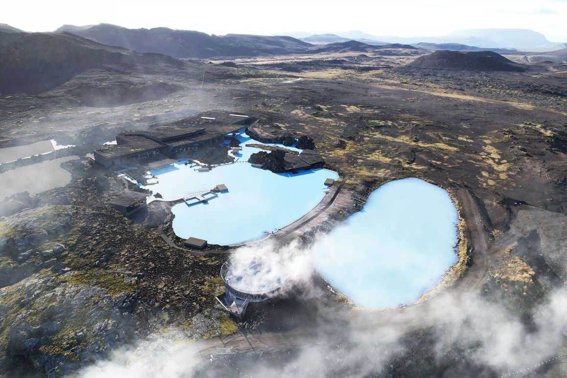 Aerial view of the Blue Lagoon in Iceland: turquoise water, black lava rock, steam rising, cloudy sky.