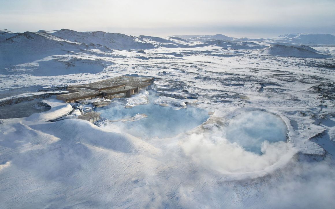 Aerial view of the Blue Lagoon in Iceland: turquoise water, black lava rock, steam rising, cloudy sky.