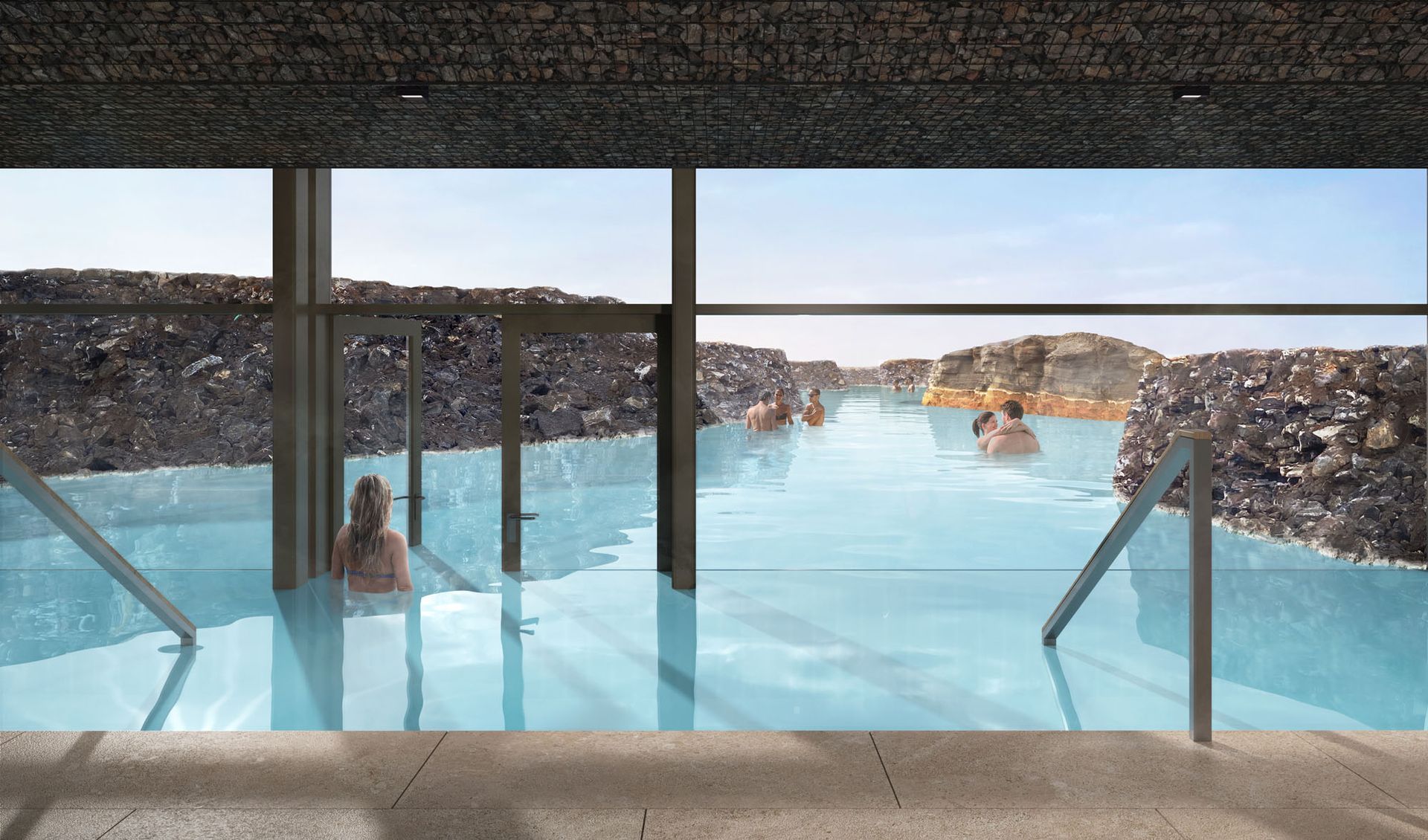 People relaxing in a blue geothermal spa with rock walls, viewed from a window.