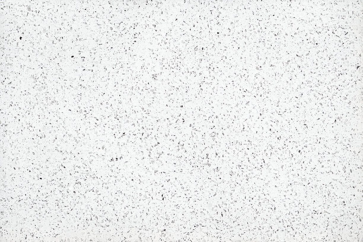A close up of a white surface with small black dots on it. A close up of a white surface with small black dots on it.