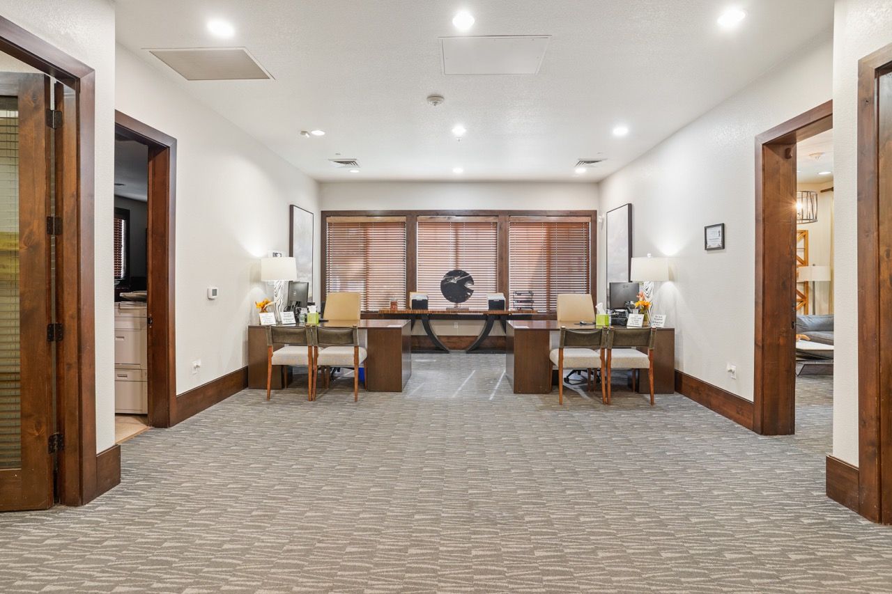 Lobby reception area with two desks, chairs, and warm lighting.