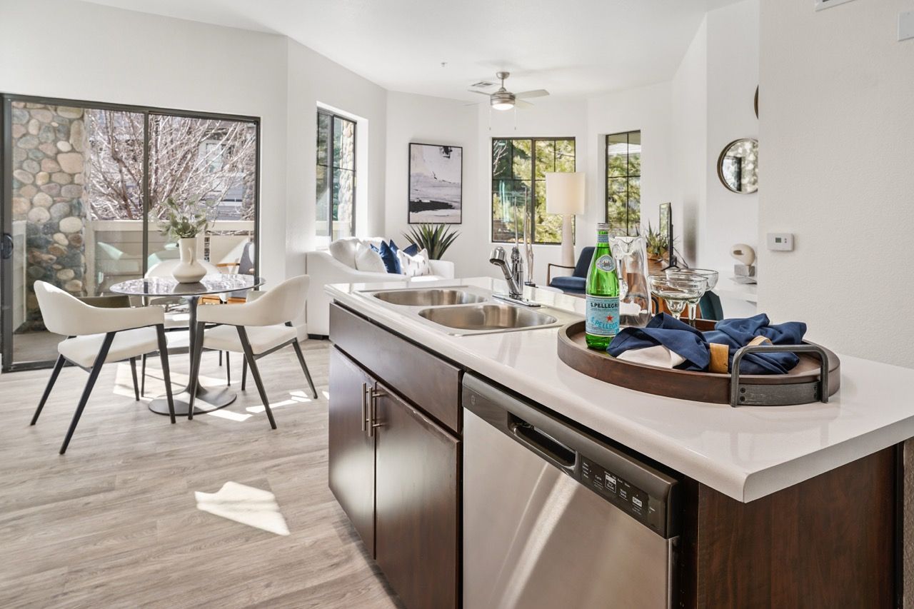 Open-concept kitchen with island and dining area in a bright apartment.