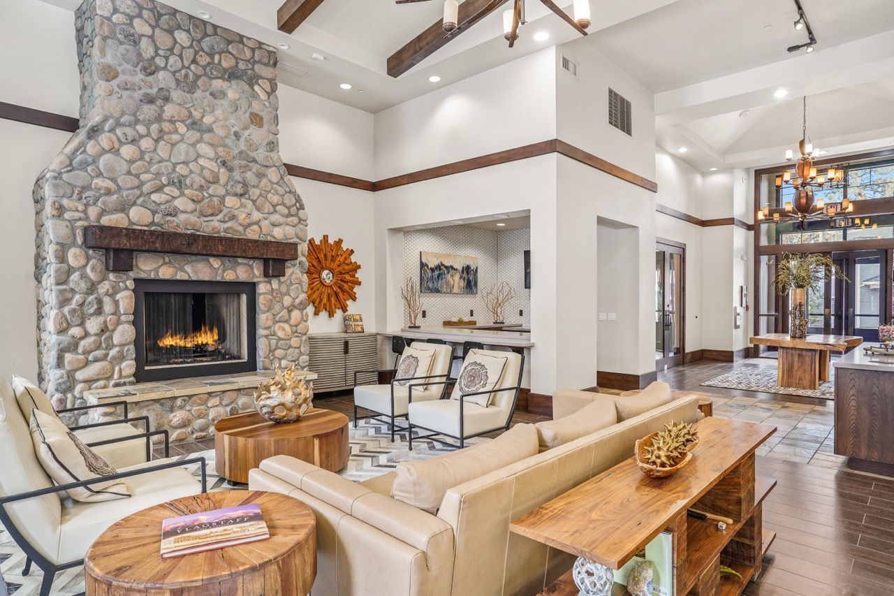 Bright community lobby with a stone fireplace, seating area, and wood accents.
