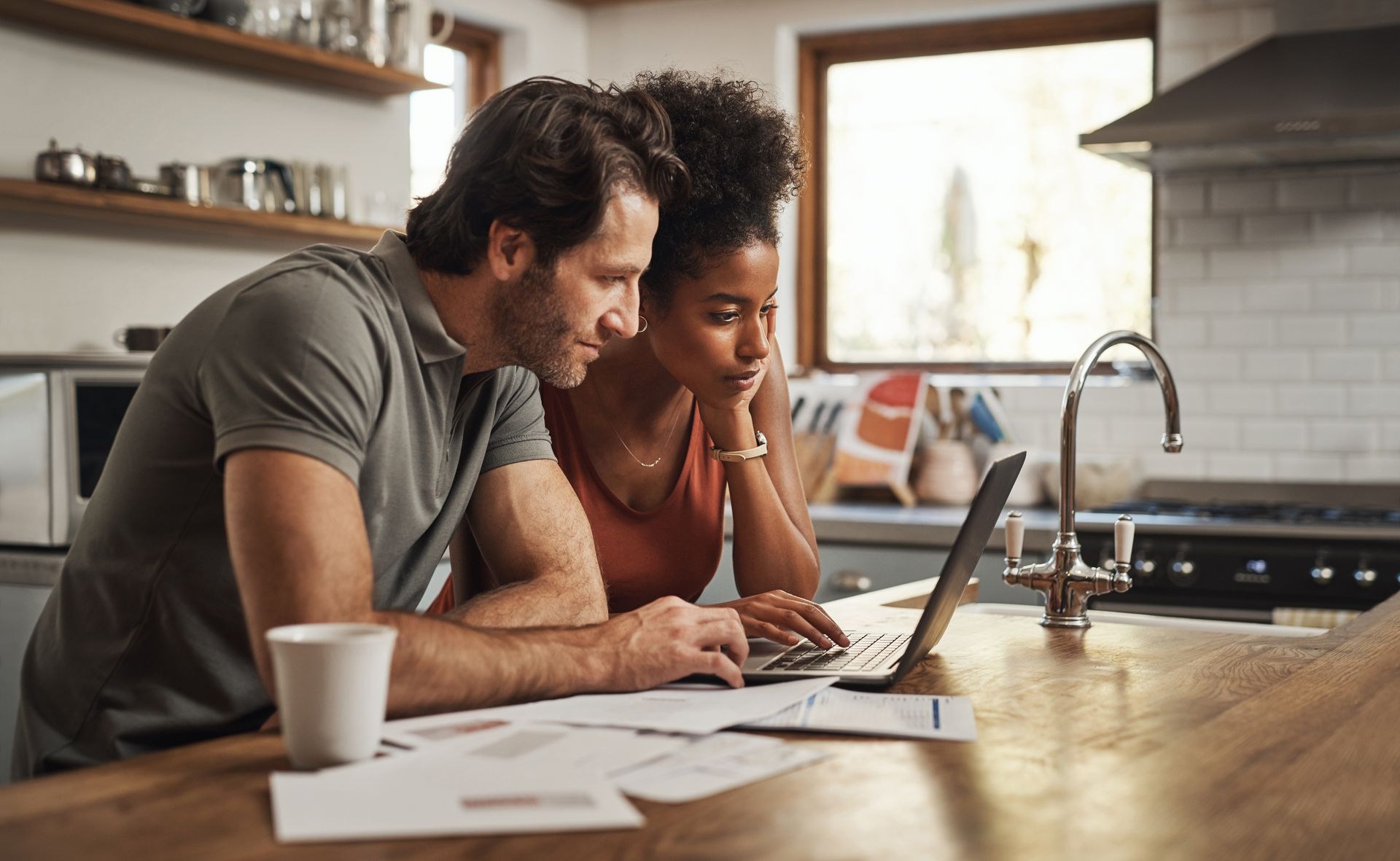 A couple working on their application for a mortgage pre-approval at their kitchen island