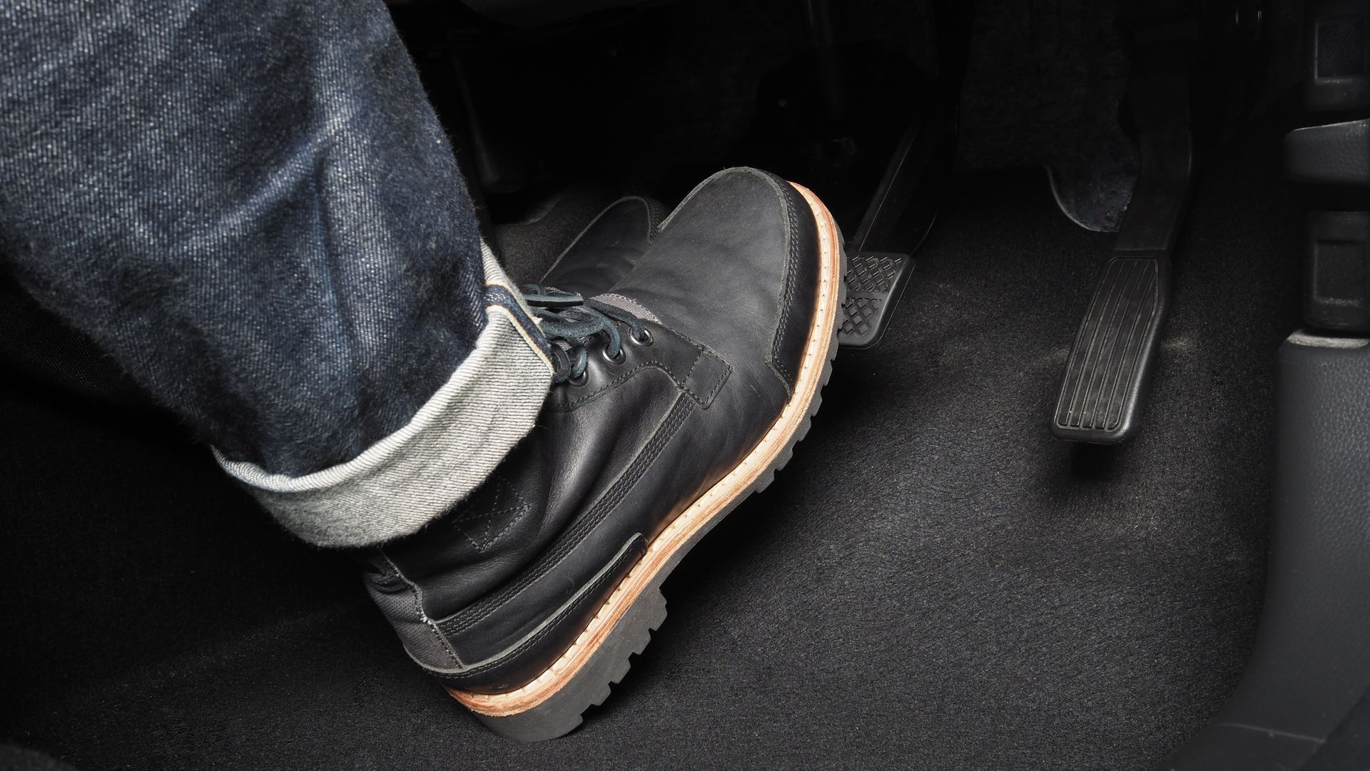 a person is pressing the brake pedal in a car .