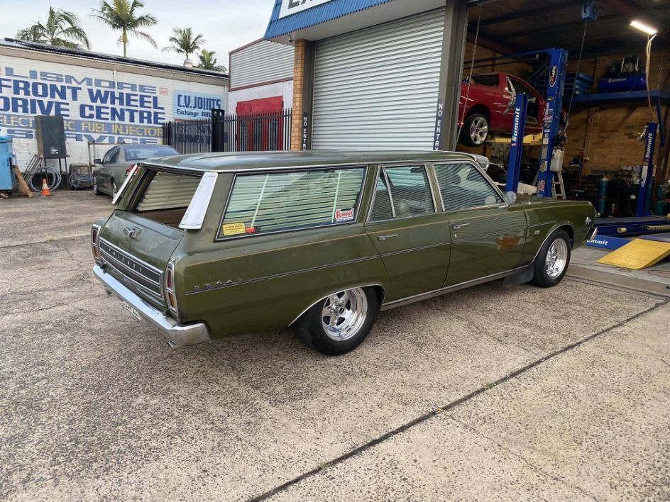 A Green Station Wagon is Parked in Front of a Garage— Savins Radiator Service In Lismore, NSW
